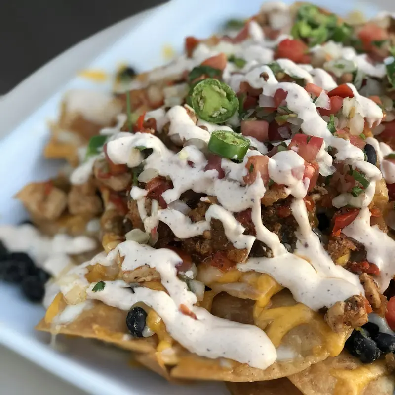 Loaded nachos topped with pico de gallo, jalapeños, and crema